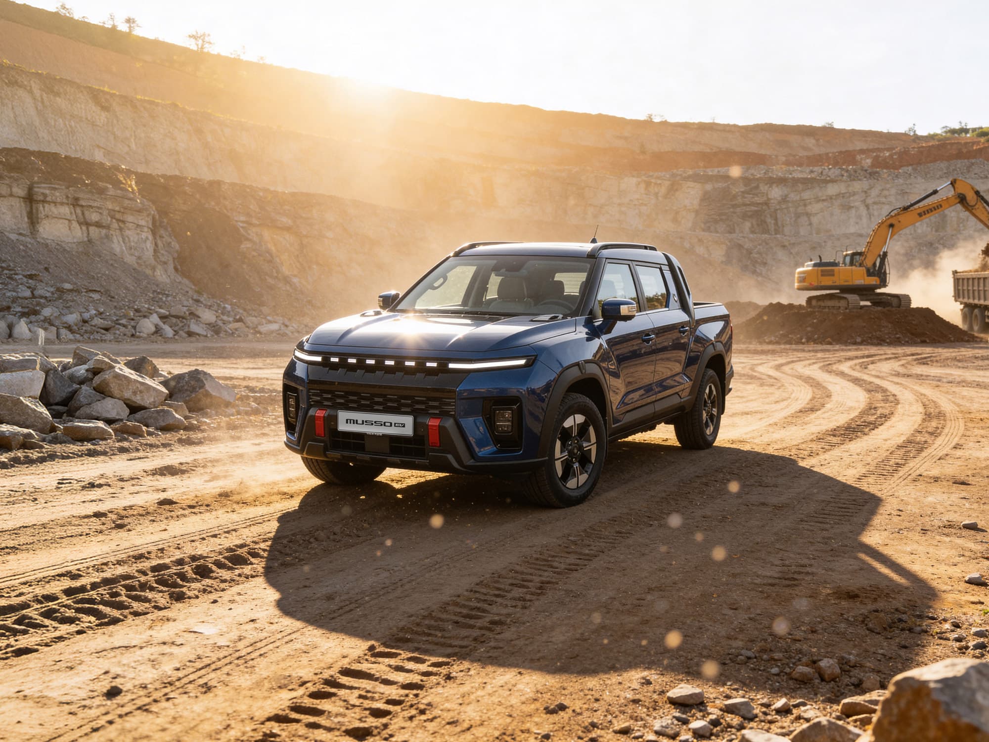 Blue Musso EV parked at a dusty construction site with an excavator in the background under bright sunlight.